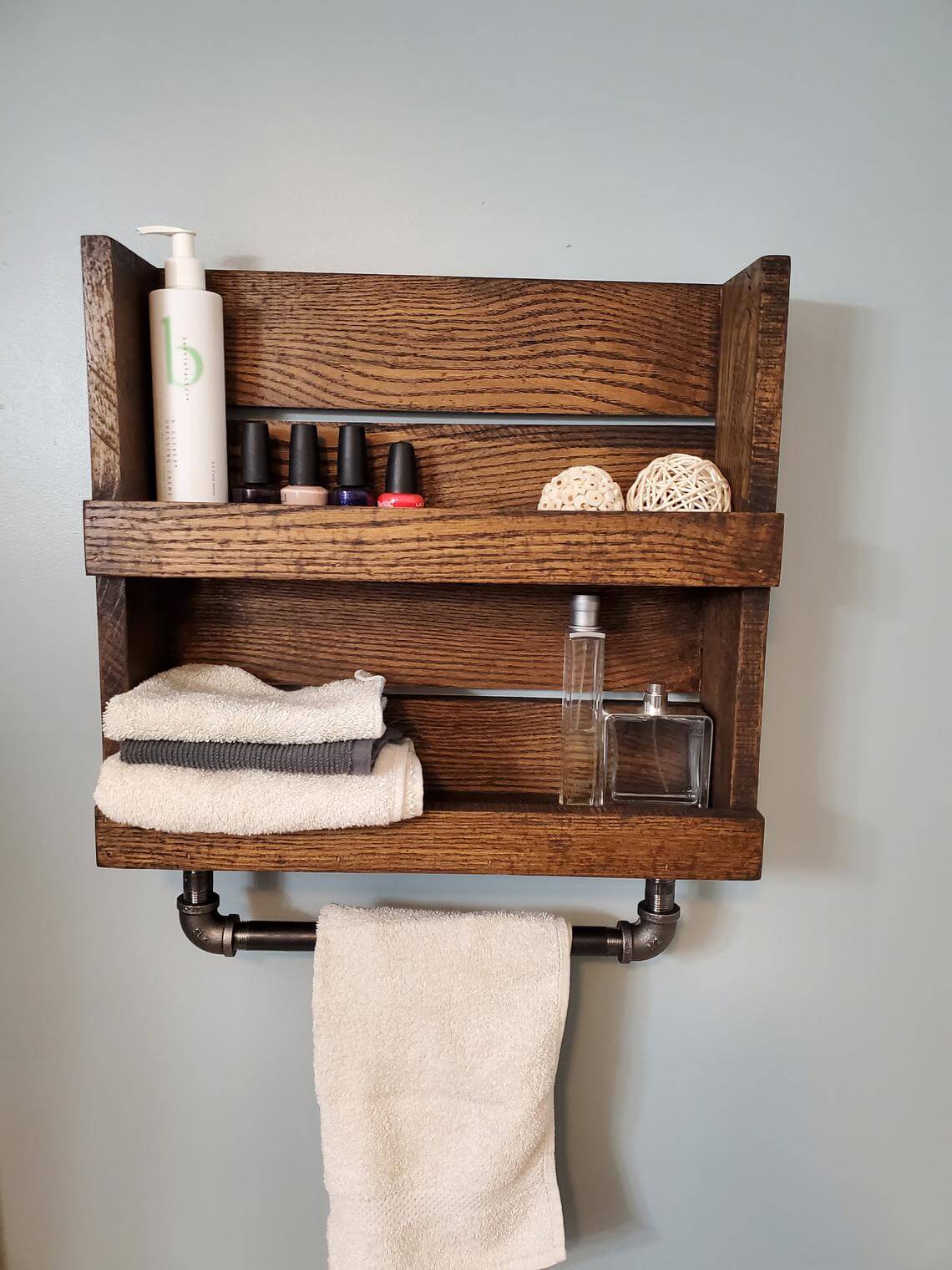 rustic wood towel rack made from a pallet with wrought iron pipe
