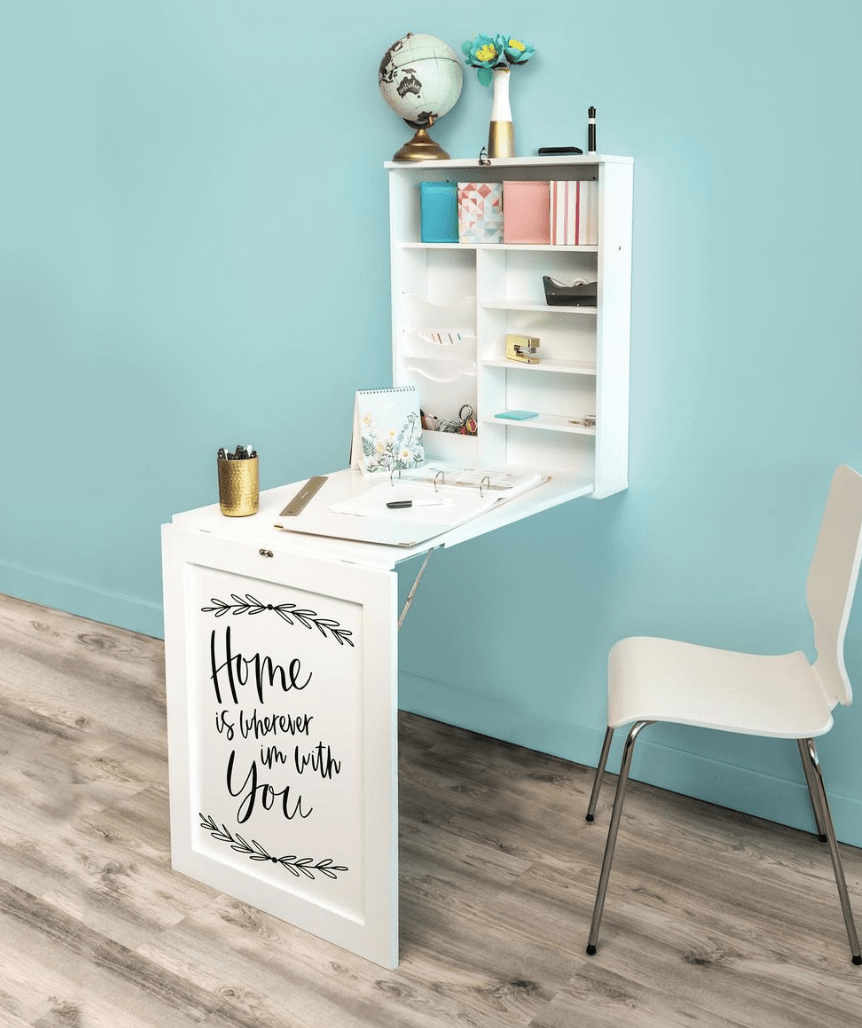 white fold down desk with inspirational saying on the front white chair in a room with baby blue wall and wood flooring