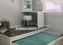 trundle bed with wood floor top open with a fold down desk on top white furry stool