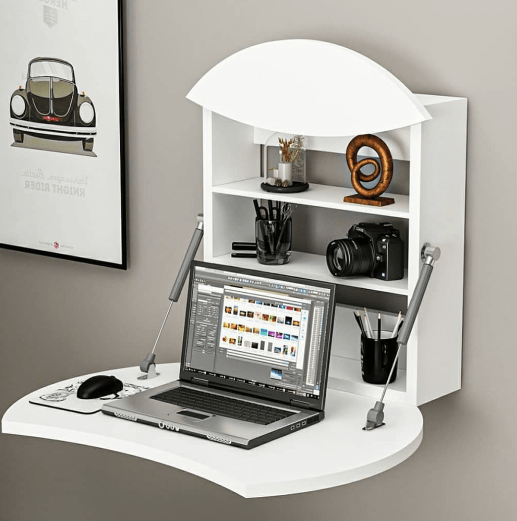 mini white fold down desk attached to wall open with laptop on it camera pencil container and decor
