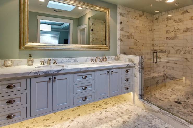 Amazing bathroom with contemporary double bathroom vanity paired with calcutta marble countertops, green bathroom walls paint color and silver beveled bathroom mirror. Calcutta marble hex tile bathroom floor and bathroom backsplash. Seamless glass shower with calcutta marble tile shower surround paired calcutta marble shower bench and green bathroom ceiling.