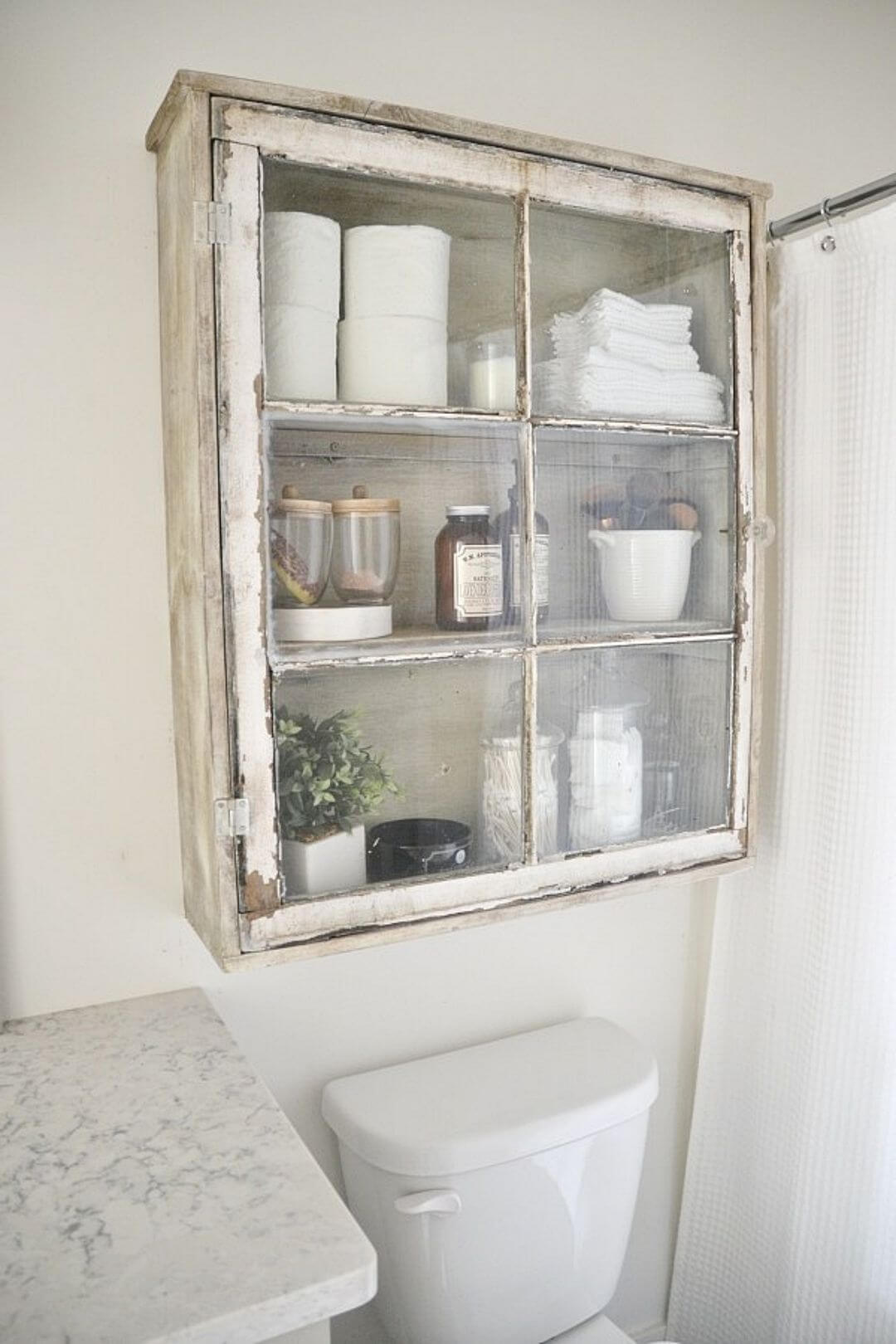 upcycled old cabinet turned over the toilet storage made with old window frame