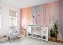 Nursery features a gray crib on a pink accent wall and a light gray rocker on a white shag rug.