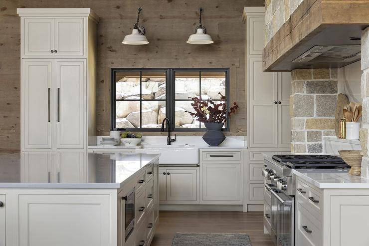 Country kitchen features kitchen island with zinc top, a stone clad cooking alcove with spice shelf on a marble look cooktop backsplash and white cabinets.