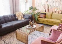 big living room with moroccan rug different colored furniture couches and chair divided from kitchen with wood slat wall