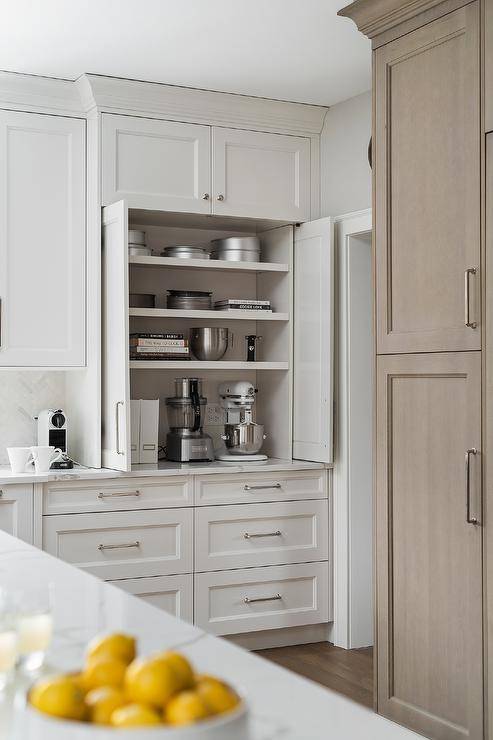 Kitchen features a small appliance cabinet with white folding doors and drawers accented with nickel pulls.