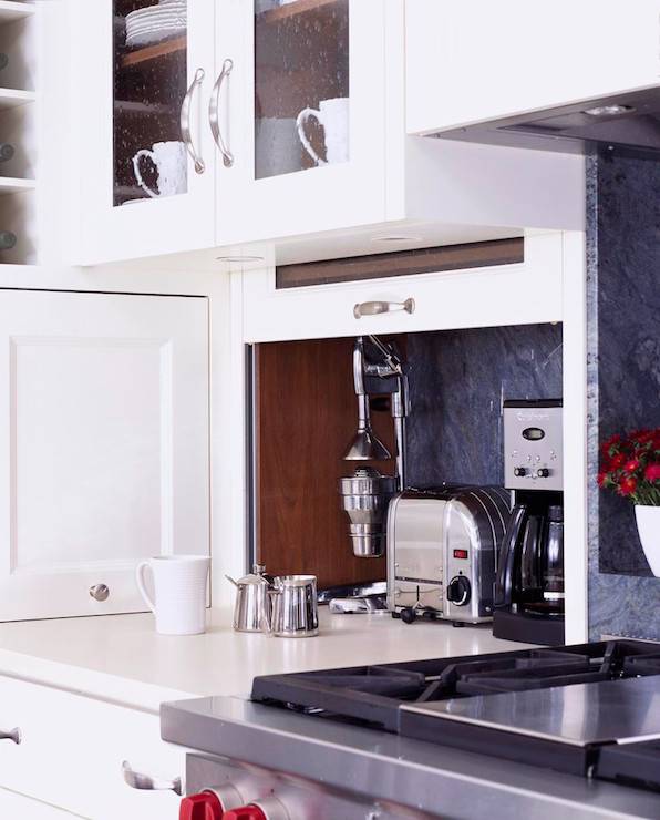 Kitchen features pull-up cabinet concealing hidden small appliances.