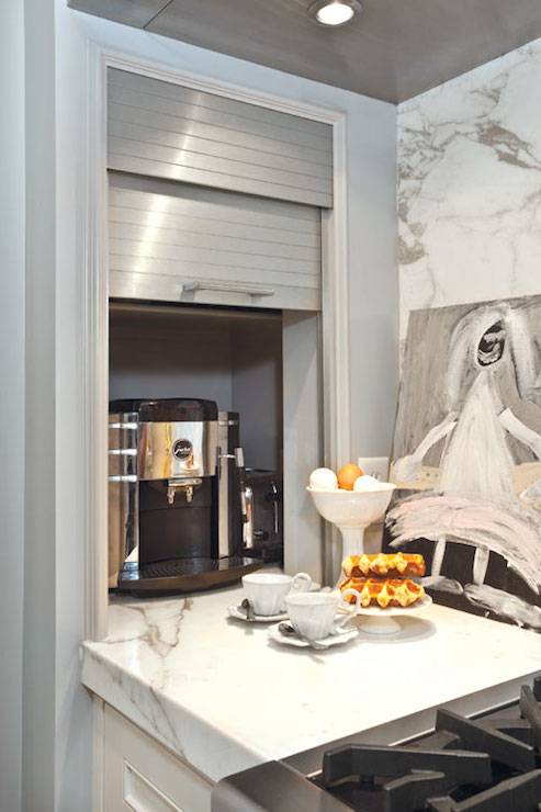 Kitchen features concealed coffee station hidden behind stainless steel garage door.