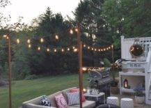 outdoor string light poles in seating area backyard