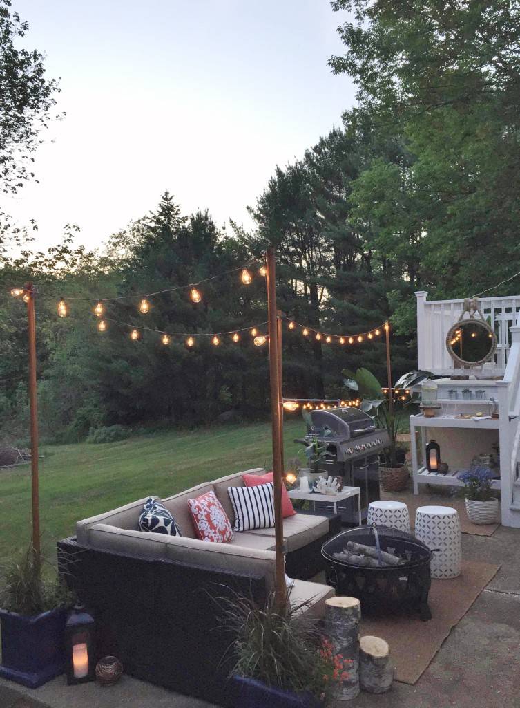 outdoor string light poles in seating area backyard