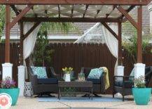 wide shot of pergola in backyard with patio furniture and turquoise blue pots