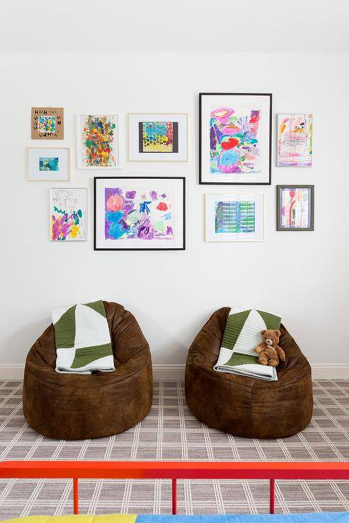 Fun boys bedroom boasting brown faux fur bean bags and accented with white and army green throw blankets. Gray plaid carpeting introduces a neutral surface complimenting any wall decor and furnishing. Eclectic wall art features colorful art pieces framed with various frames.