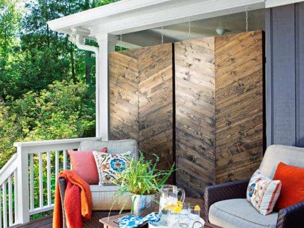 herringbone wood privacy screens on porch two sitting chairs with throw pillows