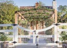 white garden gate with square chicken wire fencing and pergola