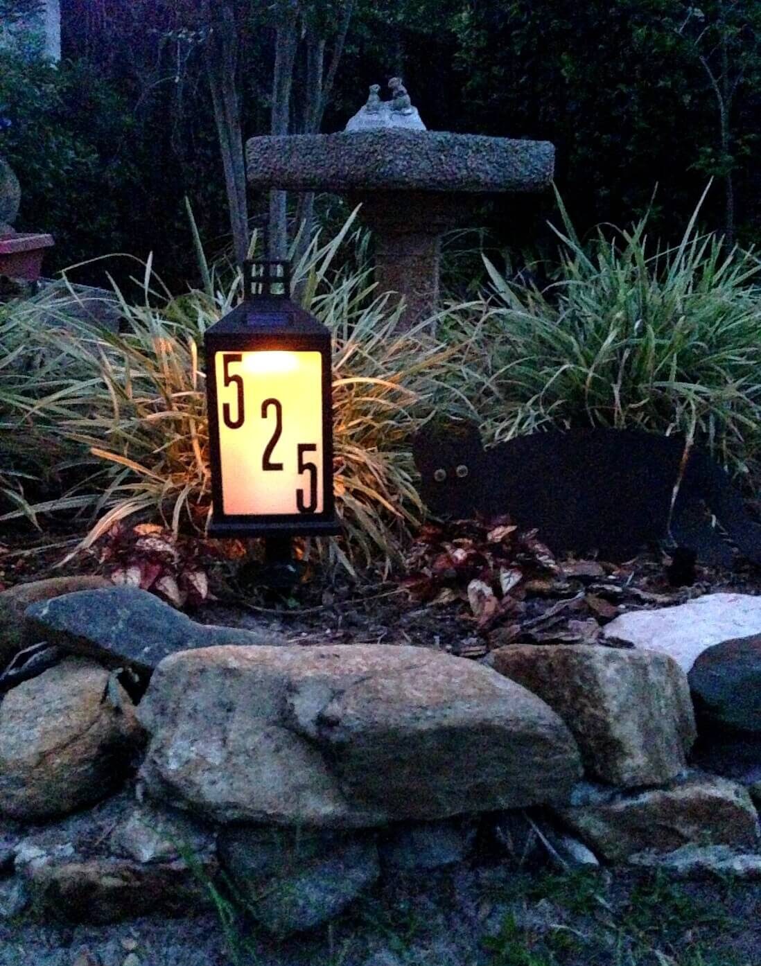 lantern house number sign in gardens on rocks lit up a night