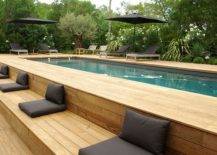 wood panel above ground lap pool with black cushions and umbrellas