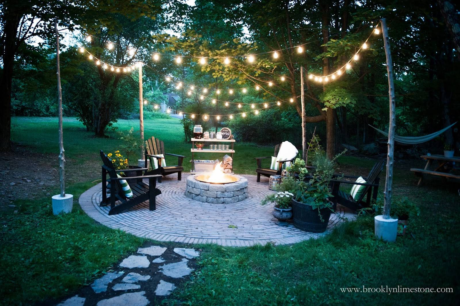 outdoor fire pit with stone path and string lights