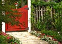 little red garden gate door with with arbor covered in moss