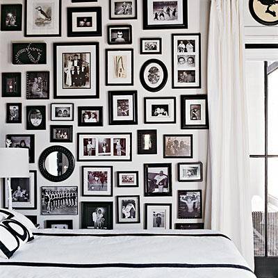 White bedroom with black and white photo wall gallery! White silk drapes, black picture frames and black & white bedding!