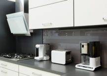 white modern kitchen cabinets with appliances on black counter
