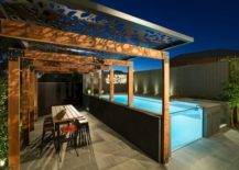 open edge above ground pool at night on patio with pergola