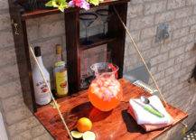 outdoor bar flip down mounted to brick wall with drinks and flowers
