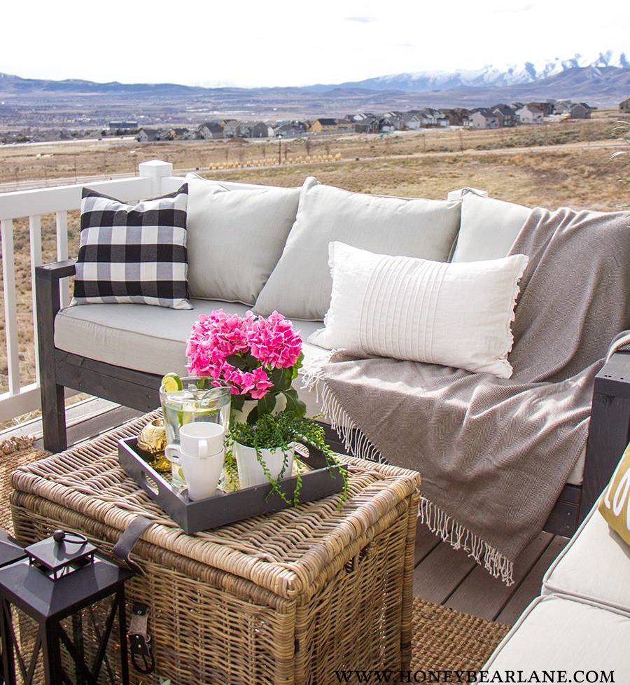 outdoor couch on porch with rattan chest coffee table throw pillows and throw blanket