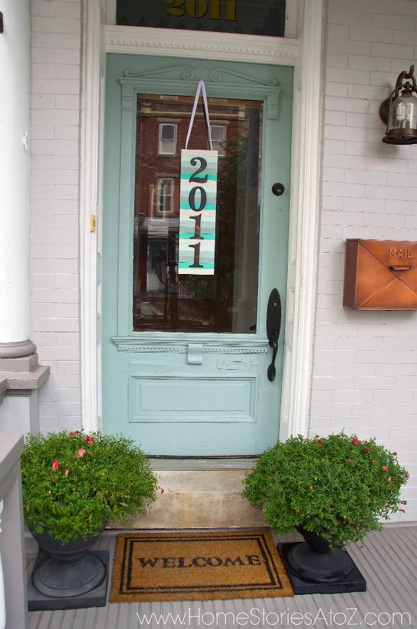 paint stick number sign light blue door with welcome mat