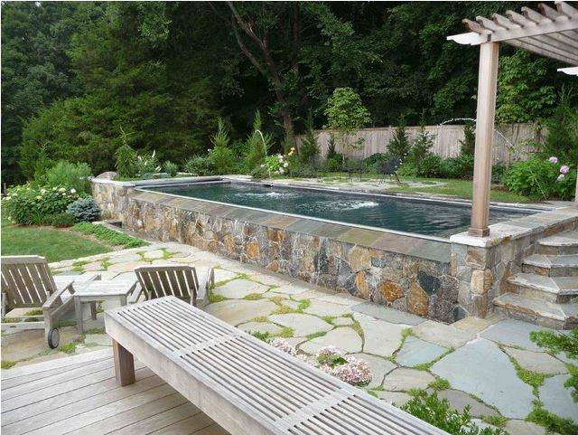 rectangle above ground pool with stone wall edging around it
