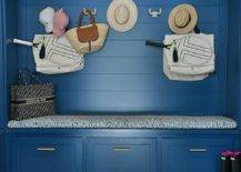 Mudroom features a blue shiplap built in bench with drawers and blue cushion and a later gator rug.