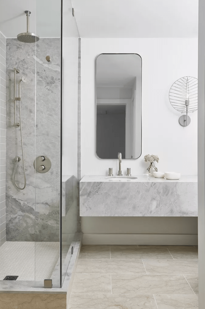 mixed marble textures basement bathroom long mirror silver accents walk in shower