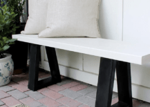 close up of white and black bench outside with two white pillows