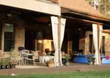 wide shot of patio with drop cloth curtains patio furniture