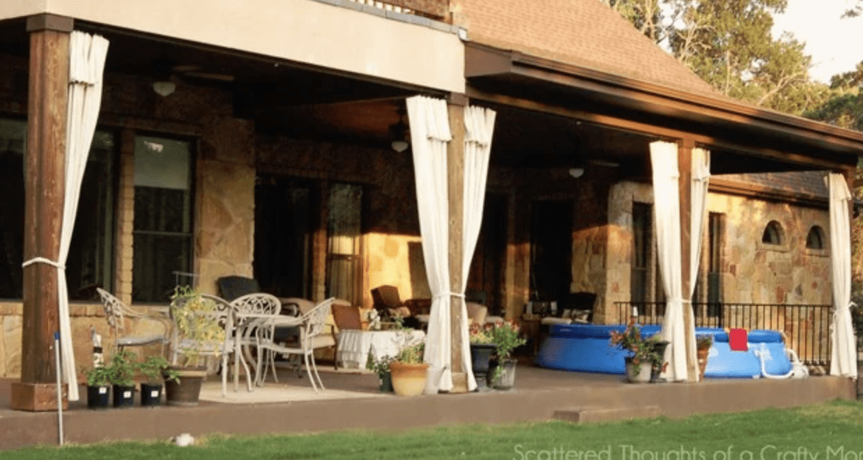 wide shot of patio with drop cloth curtains patio furniture