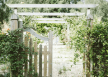 old english style wooden gate leading into a vine covered garden