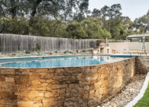 above ground pool with stone brick work wall and stones around the ground