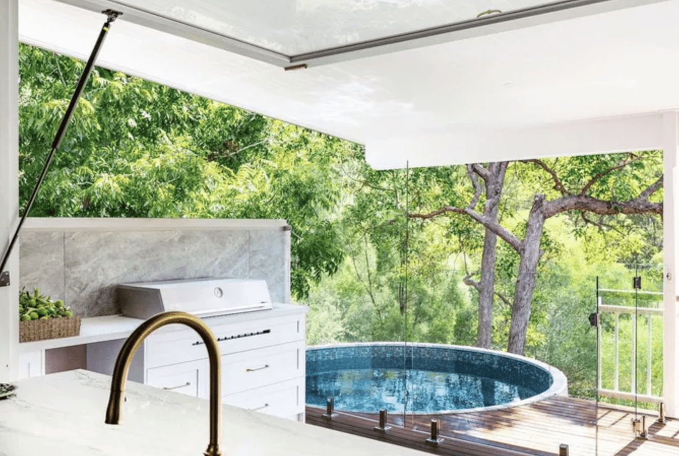 above ground pool on deck with trees in background outdoor kitchen onpatio