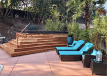 modern deck with above ground pool and two blue cushion pool lounger chairs