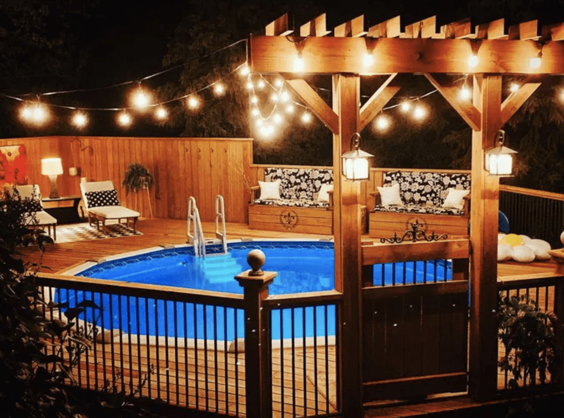 night swim pool with wood deck and string lights