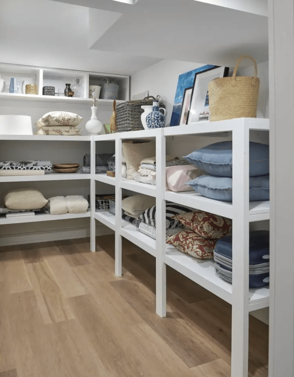white short basement shelving with pillows and blankets on it