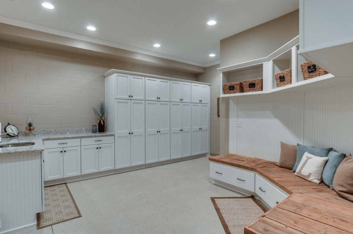 large basement with white cupboards shelving and wood top bench semi circle baskets and countertops
