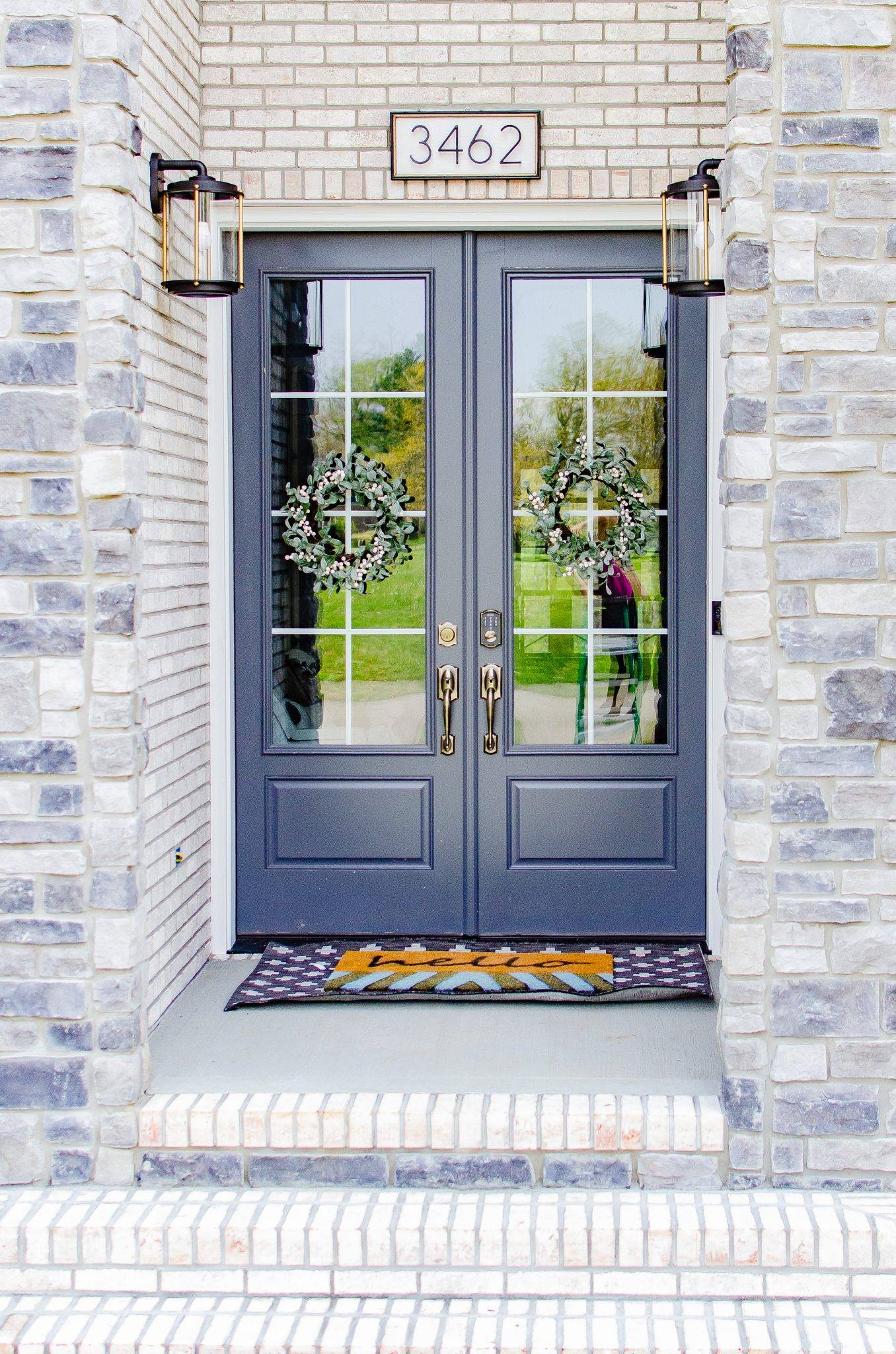 modern front porch with blue oreleans doors wreaths and modern diy house number sign