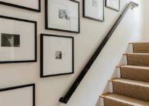 Gallery wall art staggered along a staircase wall in black frames showcasing black and white lifestyle photos.