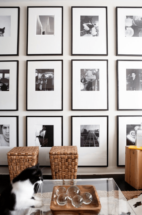Black and white photo wall gallery, baskets, acrylic coffee table, sisal rug and cowhide rug.