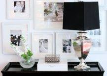 Black & white photo wall gallery, mirrored lamp with black shade, glossy white lacquer box and Bailey Street glossy black Tamara hall console table.