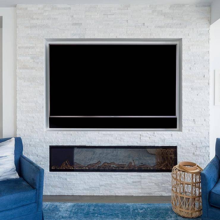A TV sits over a modern gas fireplace with white stacked stone tiles.