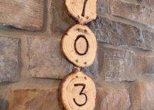 wood log slices hanging numbers on side of house