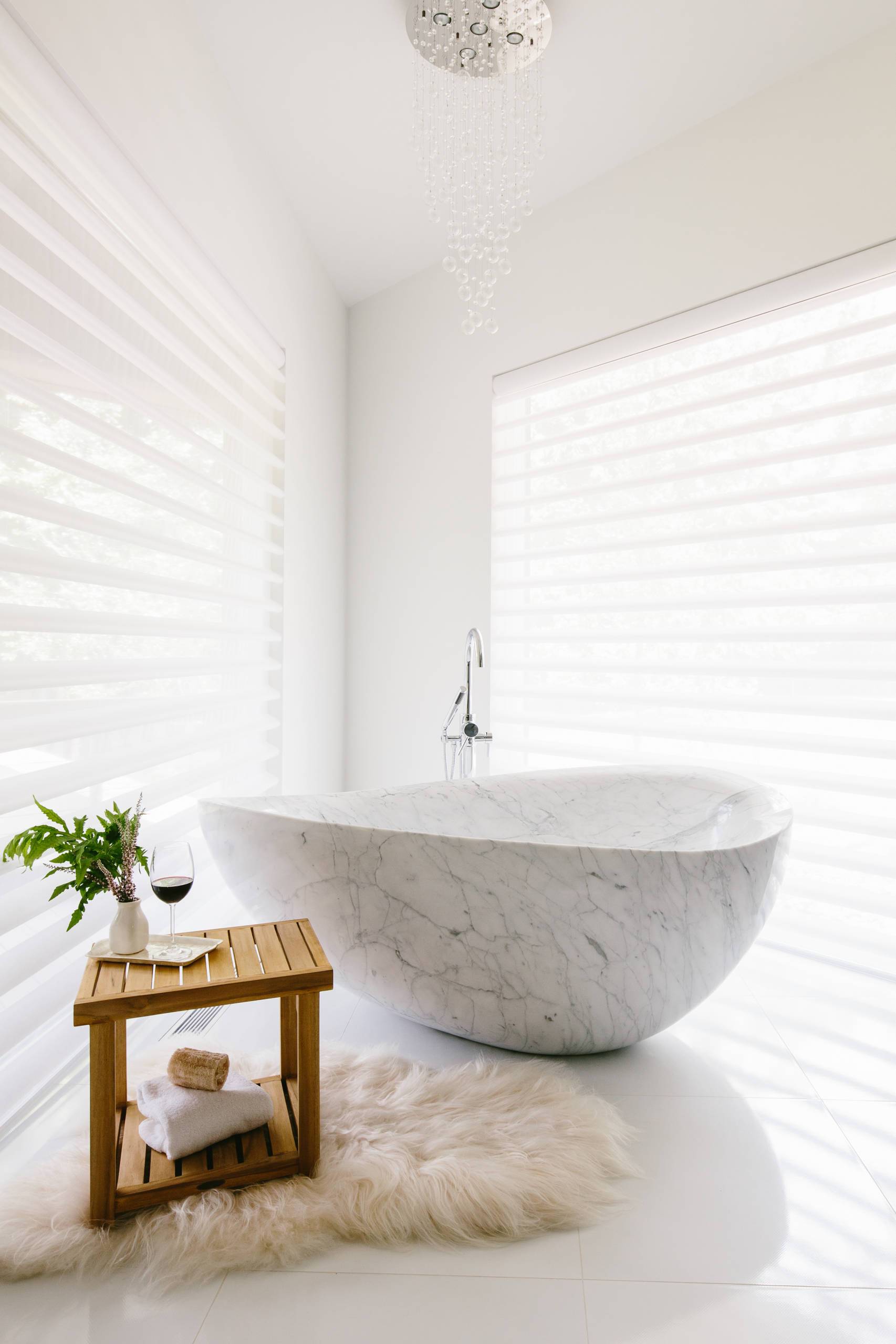 a freestanding bathtub in the corner of a large bathroom