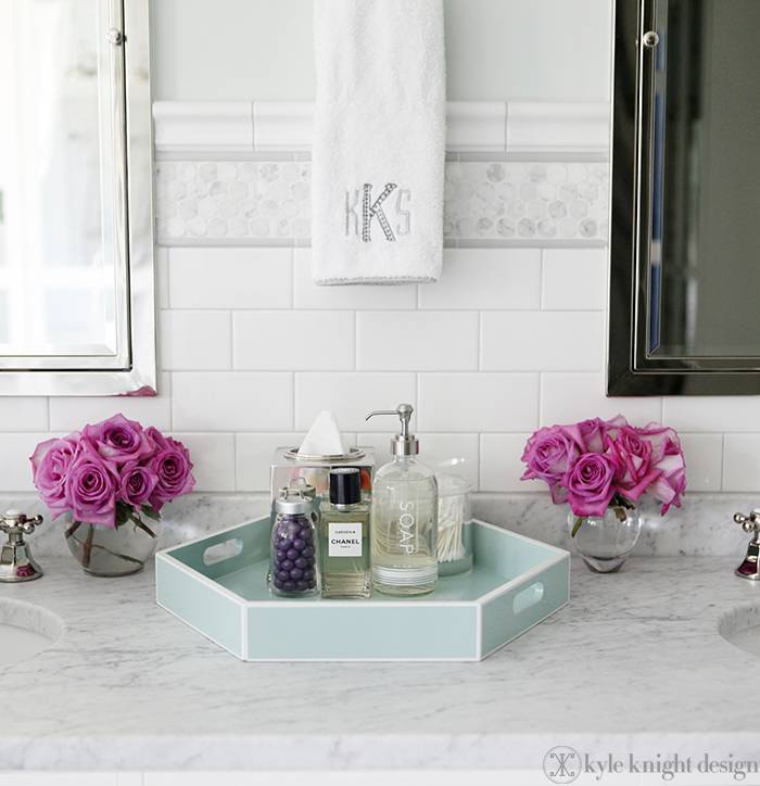 Exquisite bathroom with double vanity with his and her sinks paired with subway tile with platinum grout and carrara penny round tile backsplash. Master bathroom with carrrara marble countertops paired with Restoration Hardware Framed Inset Medicine Cabinets and Tiffany Blue octagon tray.