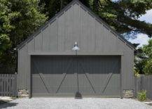 A stone and black wood garage is fitted with black dual garage doors.